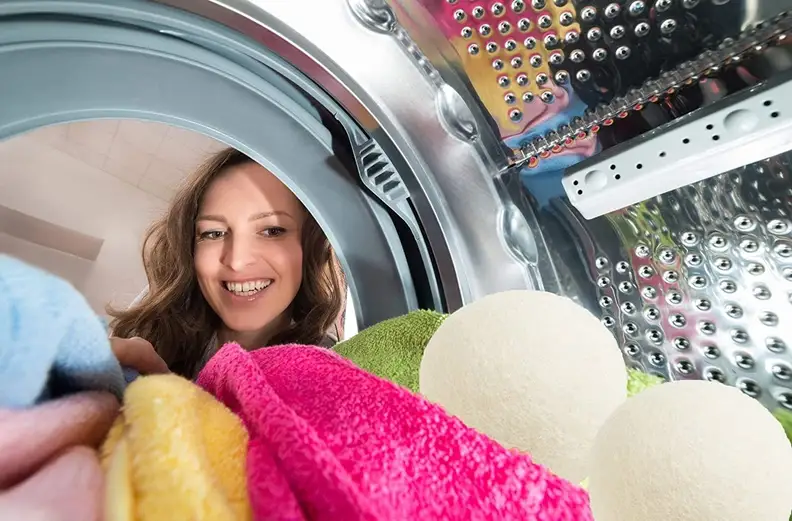 The view from inside the dryer: We see an individual’s face peeking in at the laundry, including colorful towels and a pair of dryer balls.