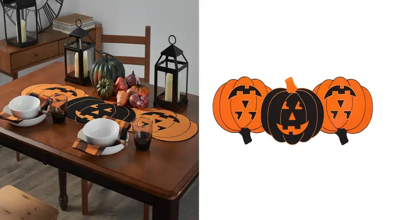 An image of a pumpkin table runner featuring three pumpkins linked together, two orange and one black at the center.