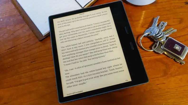 The Kindle Oasis, rested on a table, showing text from a book.