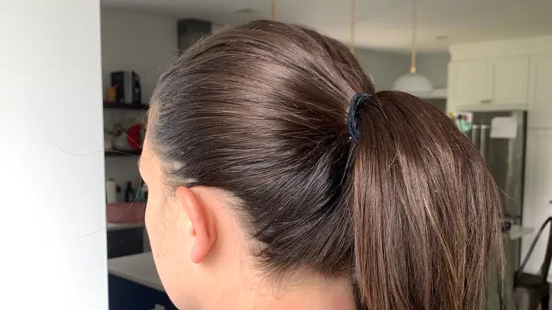 A person with long brunette hair wearing the Goody Ouchless Elastic in her hair for a ponytail.