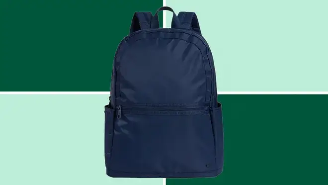 A State Kane Double Pocket Backpack on a dark and light green background.