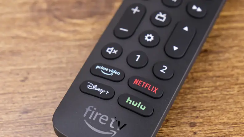An Amazon Alexa Voice Remote Pro rests on a wood surface.