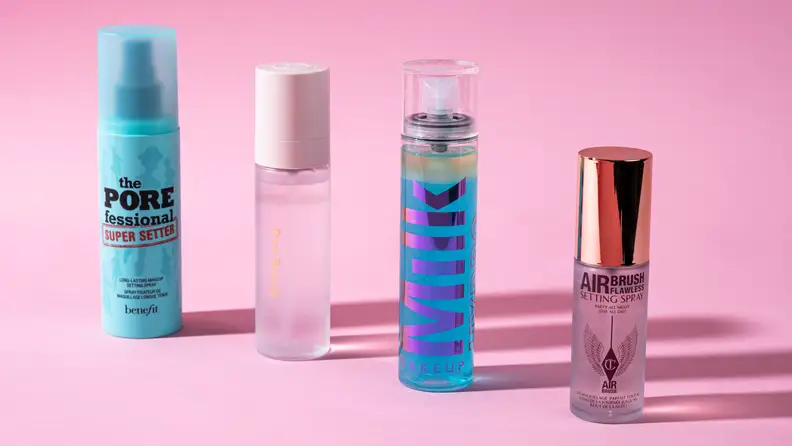 Four bottles of makeup setting spray on a pink background.