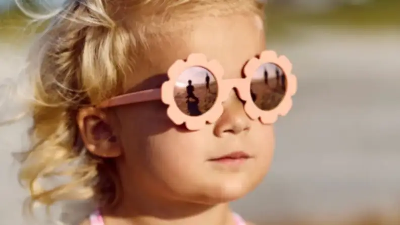A girl with adorable pink flowered sunglasses.