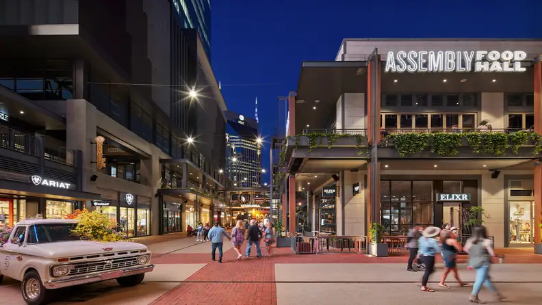 Nighttime street view of Assembly Food Hall's lit-up marquee