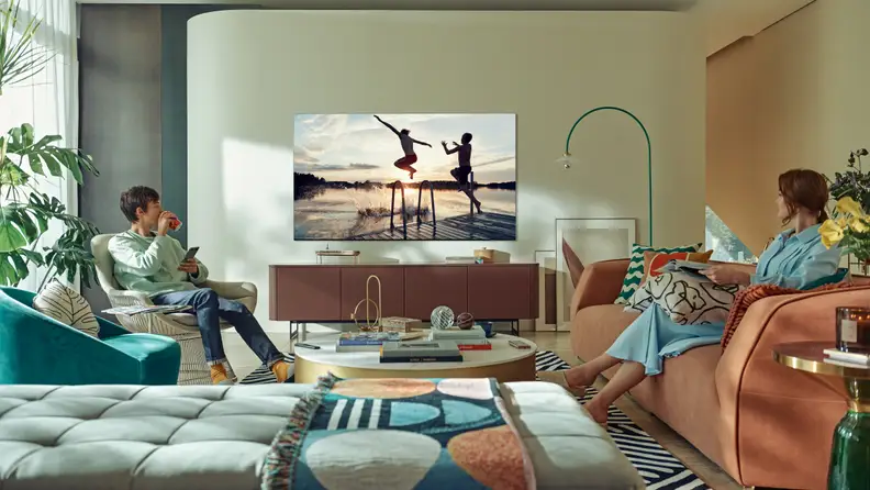 A couple individuals watch TV while lounging in the living room.