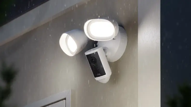 White and black ring camera with floodlights on outer wall