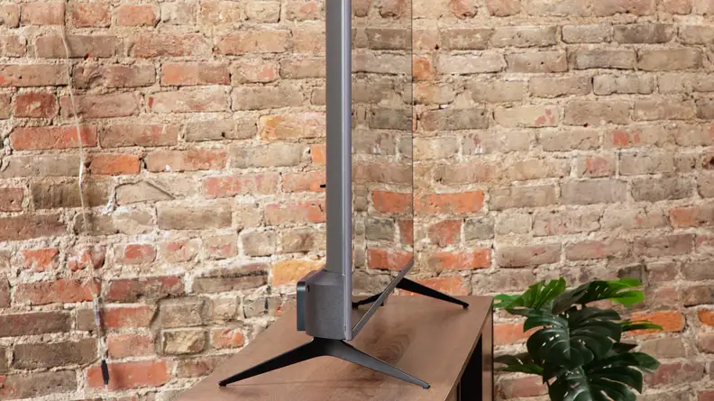 Angled shot of the Roku Plus Series QLED TV on a TV stand.
