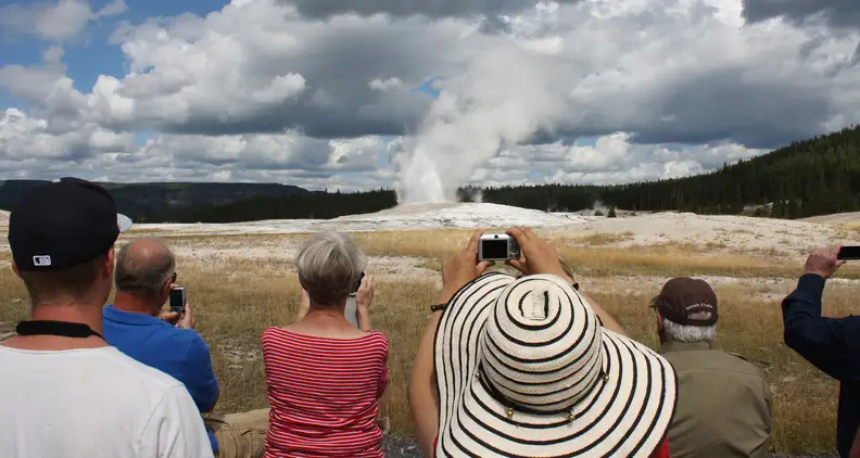 Tourists at Yellowstone's Old Faithful geyser line up to grab the same shot. [Credit: Flickr user 