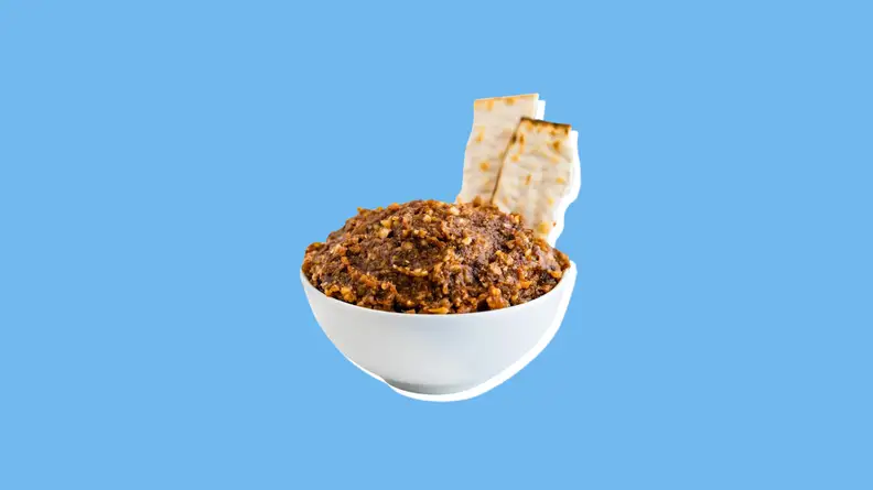 Small bowl of charoset with two sticks of matzo sticking out.