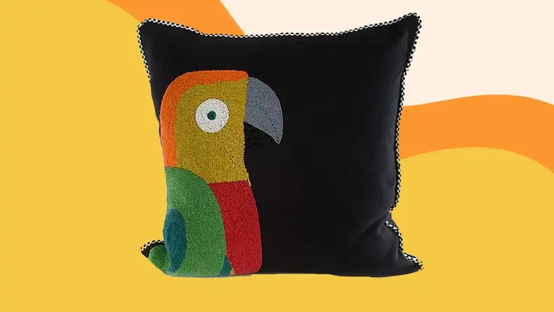 A parrot pillow against a yellow background