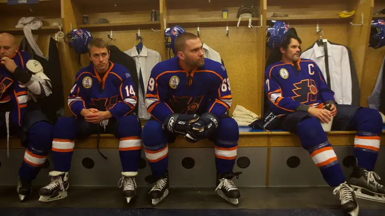 Four hockey players sitting in the changing room