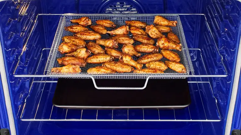 Some chicken wings being prepared inside the oven.