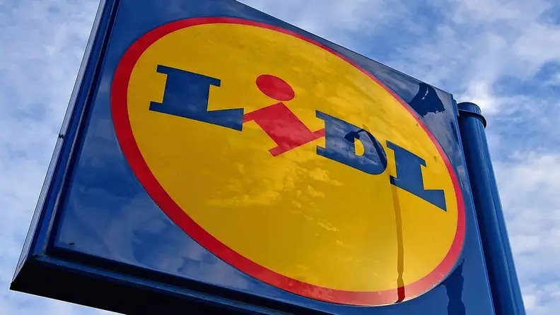 Close-up of the Lidl logo sign against a cloudy sky