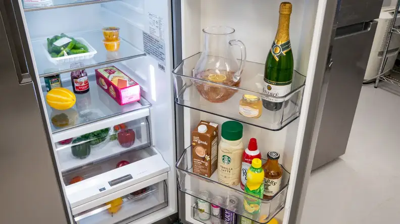 Close-up shot of interior door storage on the Midea MRS26D5AST Side-by-Side Refrigerator.