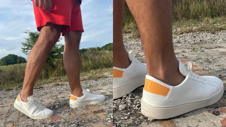 Man wearing red shorts wearing pair of Thousand Fell Lace Up sneakers with yellow accents..