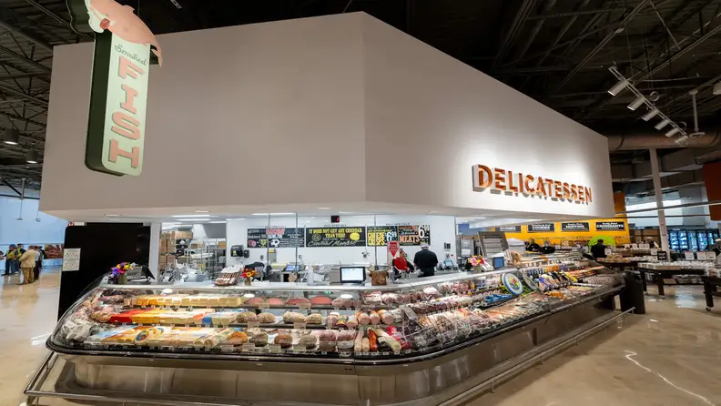 Central Market deli counter with cheese, meats, and "Smoked Fish" sign