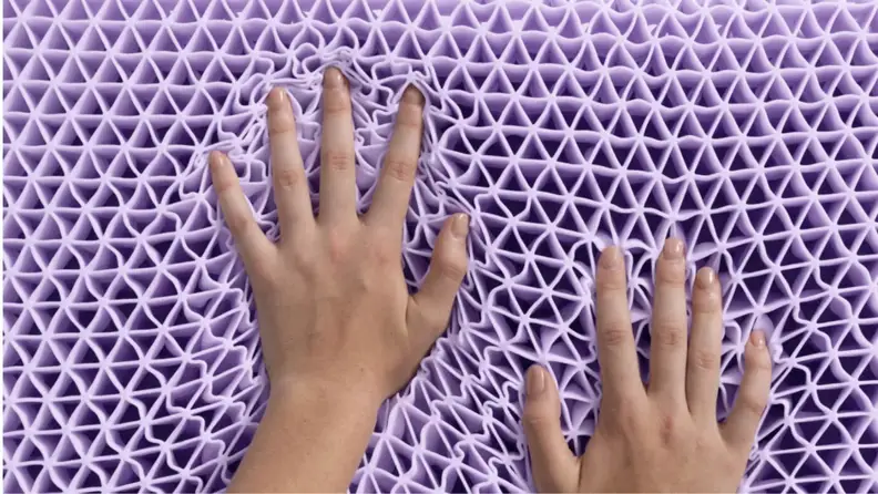 a pair of hands press into the purple polymer grid used in the Purple Pillow