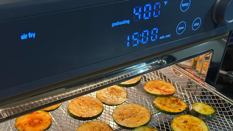 Our Place Wonder Oven Pro air fryer cooking zucchini slices.