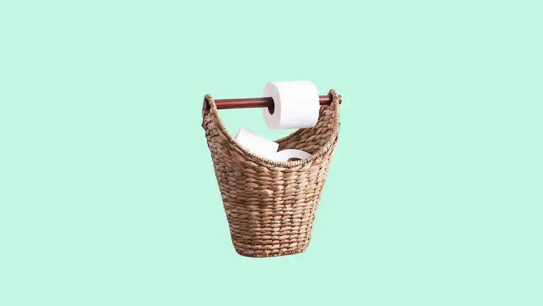 The Pottery Barn Seagrass Handcrafted Toilet Paper Holder in front of a background.