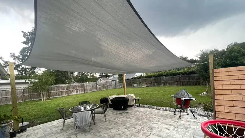 The image shows the shade sail installed over the patio.