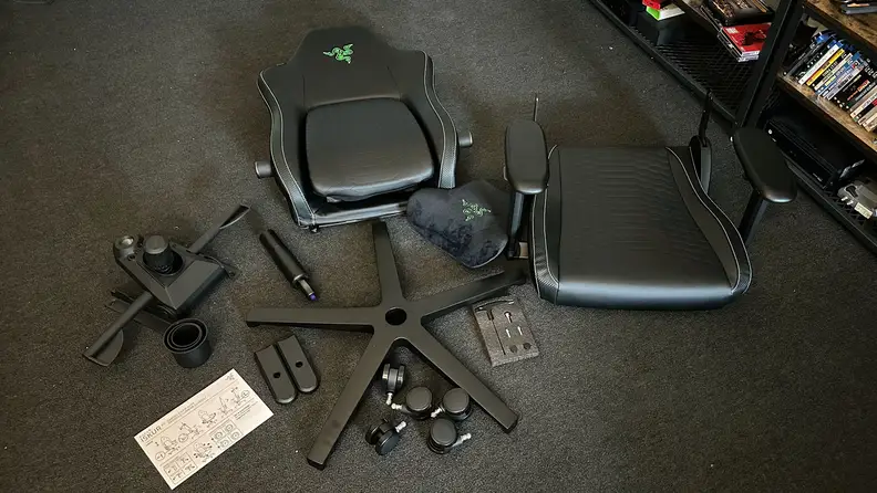 A picture of the Iskur V2 gaming chair before assembly. The individual parts are arranged on a carpet.