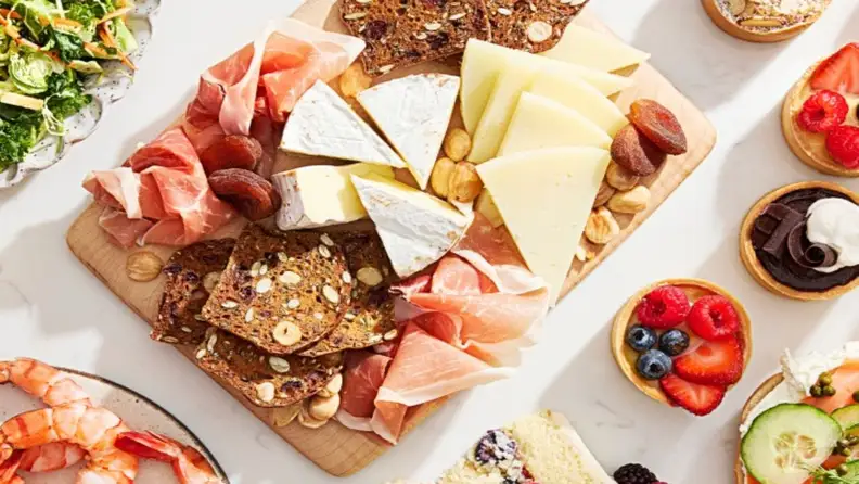 Charcuterie board with prosciutto, cheese, and crackers