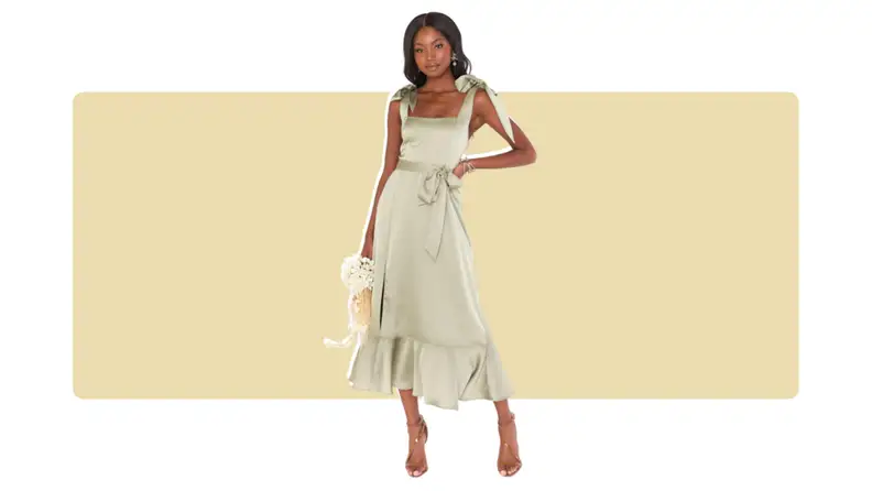 A satin green dress with bows along the waistband and shoulder straps.
