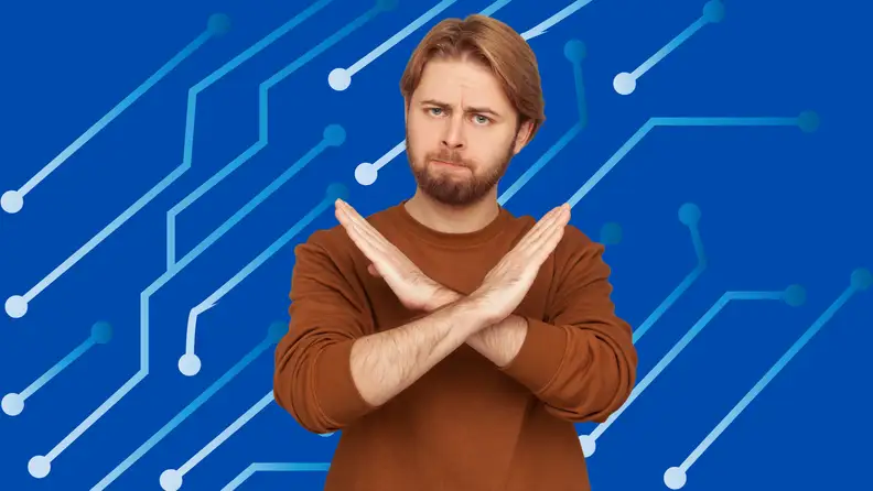 A man stands with crossed arms in front of a blue background