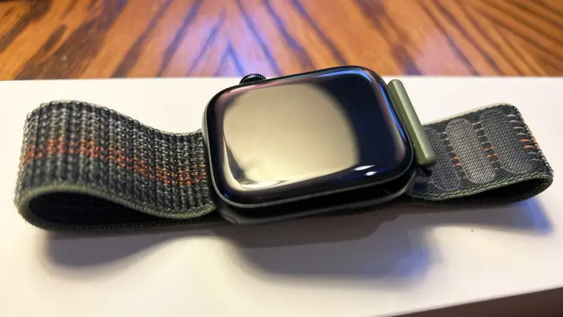 A midnight blue Apple Watch sits on a white box on a table top.