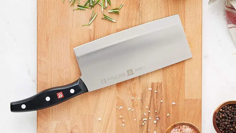 The  Zwilling Professional cleaver knife atop a wooden cutting board.