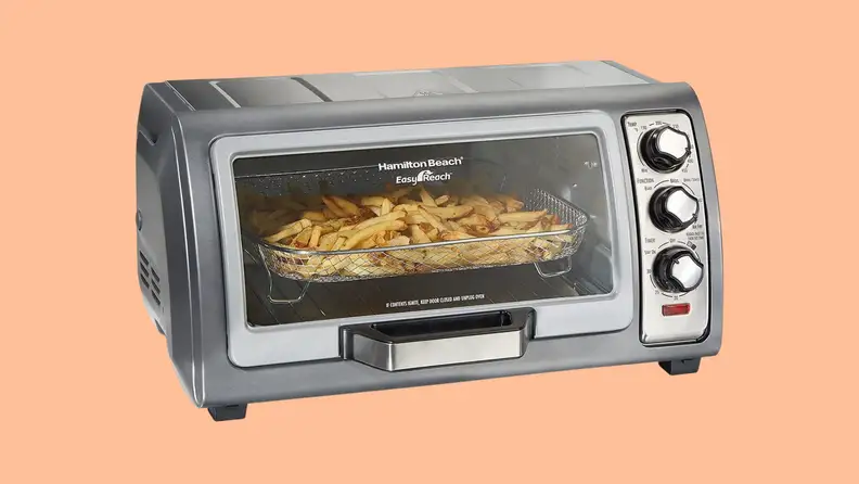 A Hamilton Beach countertop toaster oven against a peach color background.