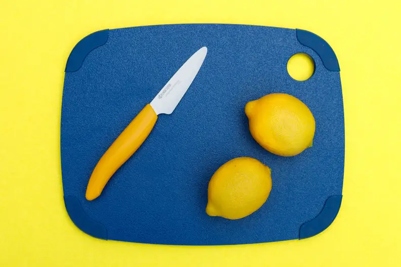 A plastic cutting board with lemons