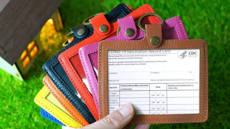 Hand holding seven multi-colored leather holders.