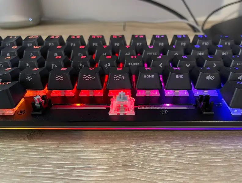A closeup view of a small black keyboard, including a red key switch.