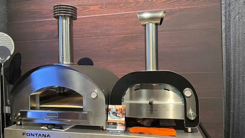 Two metal pizza ovens on a display