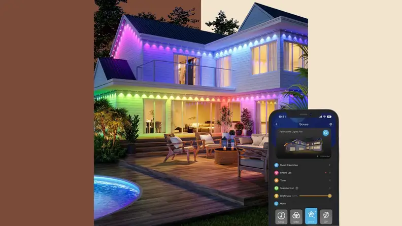 A home lit with colorful Govee Permanent Outdoor Lights Pro along the roofline and patio, with the Govee app shown on a smartphone.