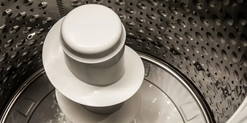 A pole agitator moves the laundry around the machine