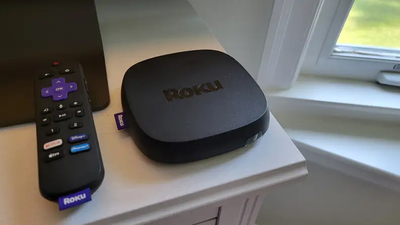 The Roku Ultra and its remote sitting on a white counter top.