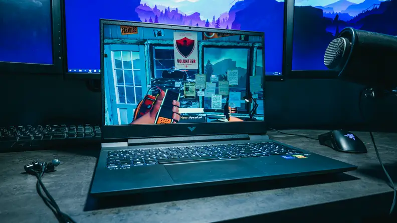 Laptop pictured on a desk under a light