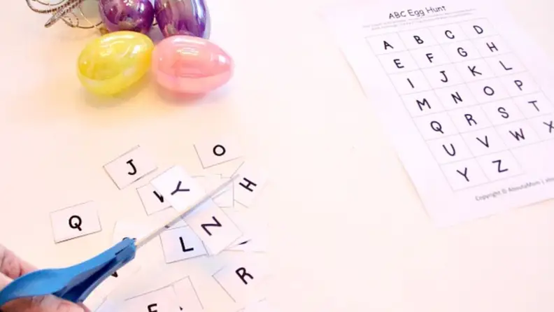 A printout of alphabet letters beside Easter eggs and scissors.