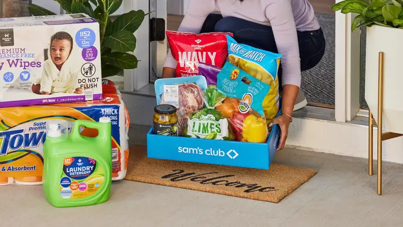 A Sam’s Club delivery box filled with groceries and household essentials on a front porch.