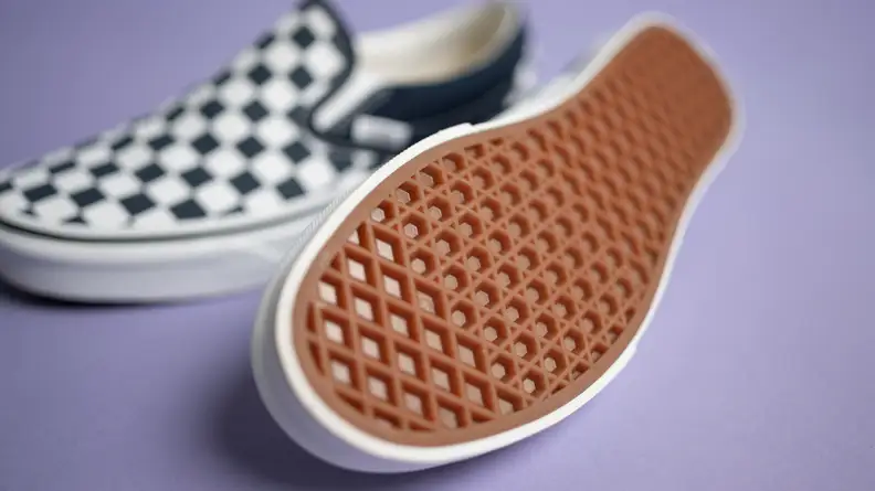 Close-up shot of the Vans Checkered slip-ons, with one of them showing the sole.