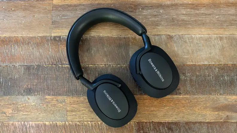 The Bowers & Wilkins Px7 S2 headphones lying flat on a wooden table.