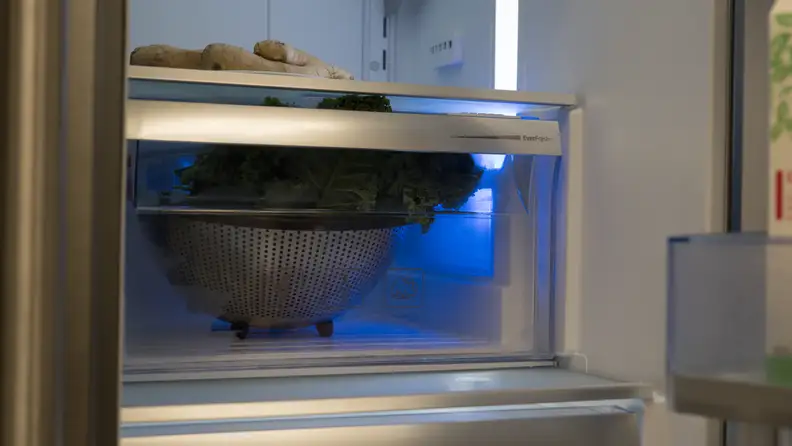 A close-up of the crispers, illuminated by their blue LEDs.