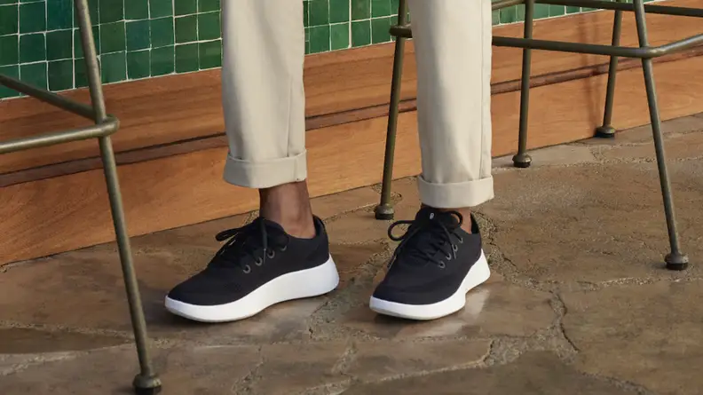 person wearing chinos and black allbirds sneakers