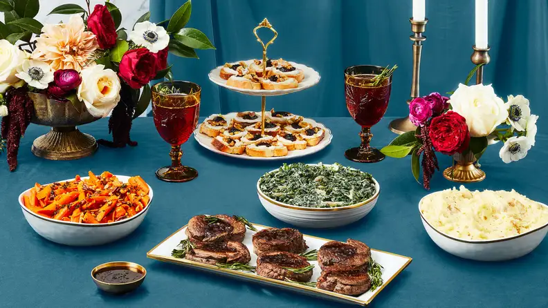Beef tenderloin on a decorated holiday table with sides.