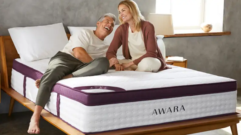Two people laying on a Awara Premier mattress in a bedroom setup.