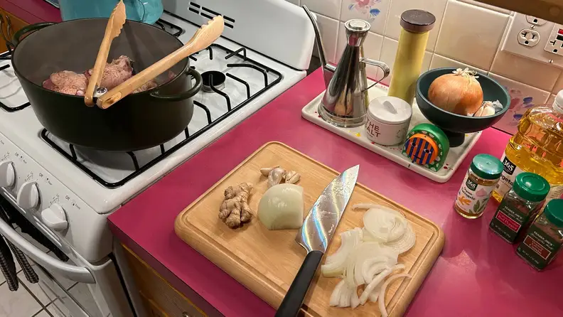 The Caraway prepware in a kitchen while something's getting cooked.