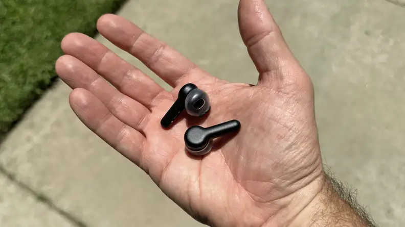 A hand with the Amazon Echo buds.